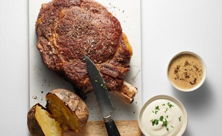 Côte de boeuf pommes de terre au four, crème aigrelette & sauce au poivre